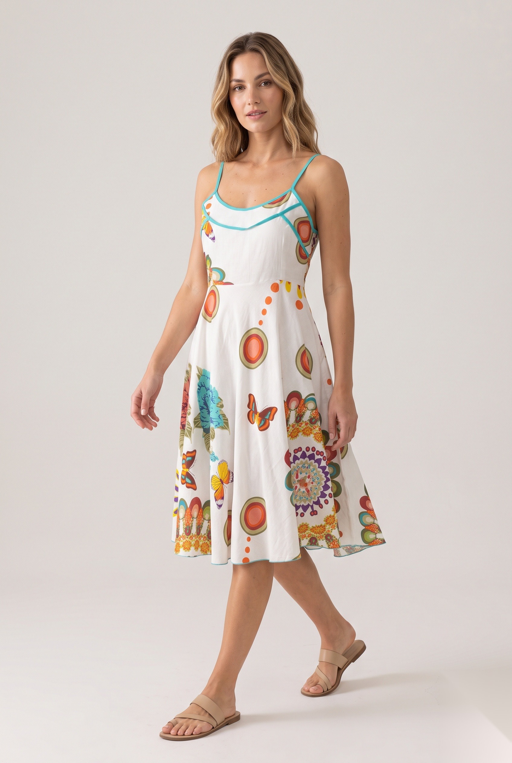 White floral and butterfly print sundress with turquoise piping worn by a model, KK Fashion Exports