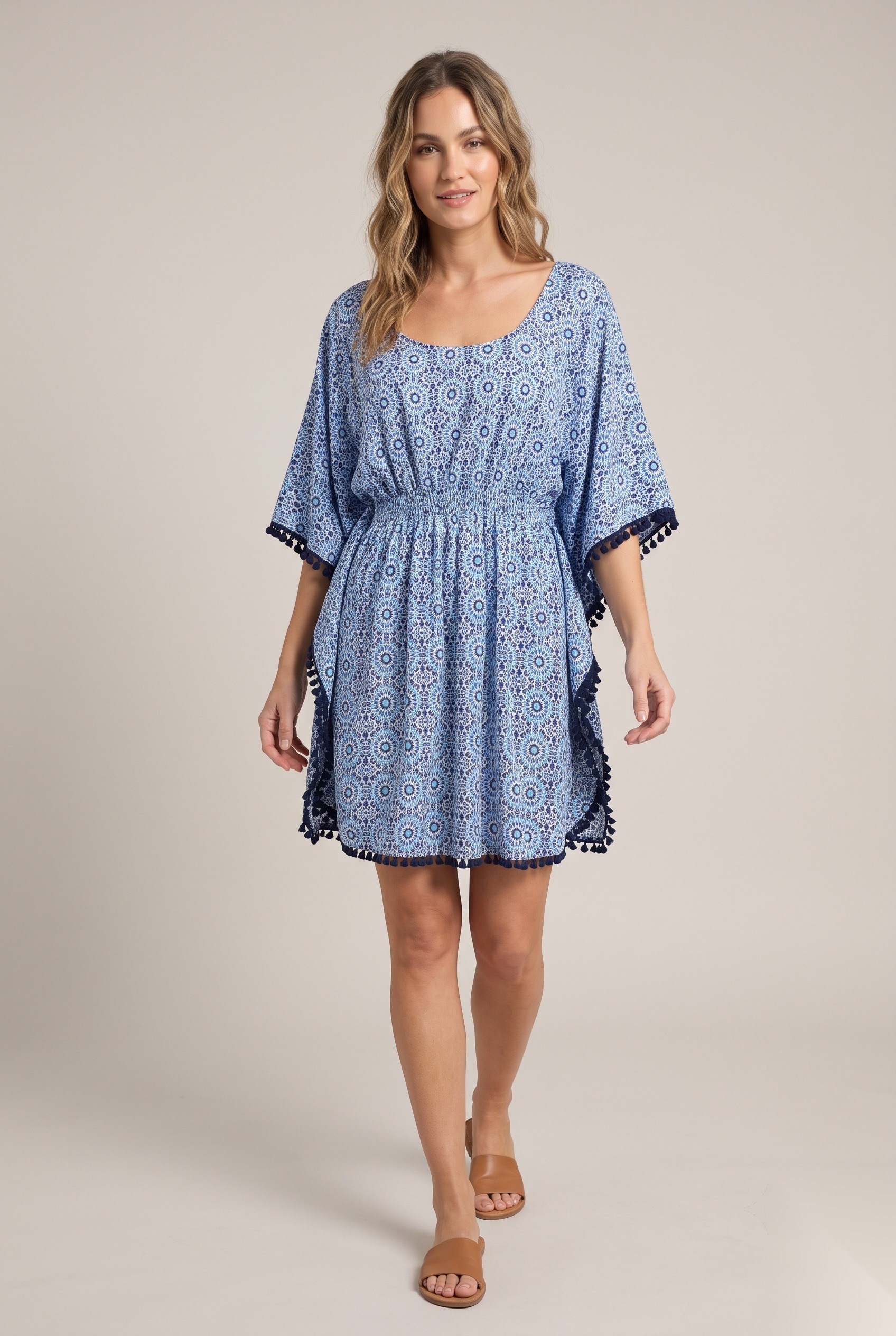Blue mandala print beach kaftan dress with smocked waist and pom-pom trim worn by a model, KK Fashion Exports