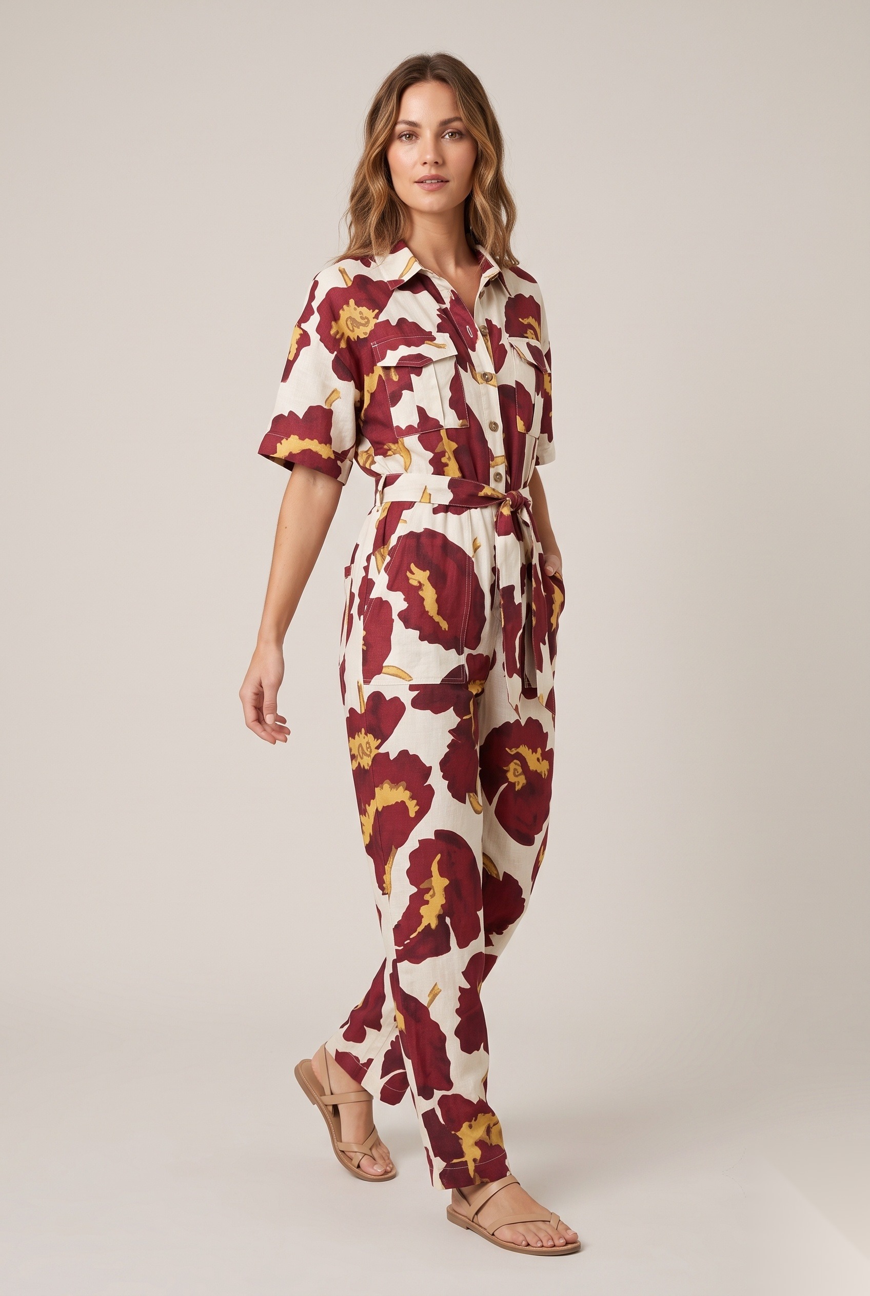 Linen belted utility jumpsuit with short sleeves in a oversized bold flower blooms with ruffled petal edges print.