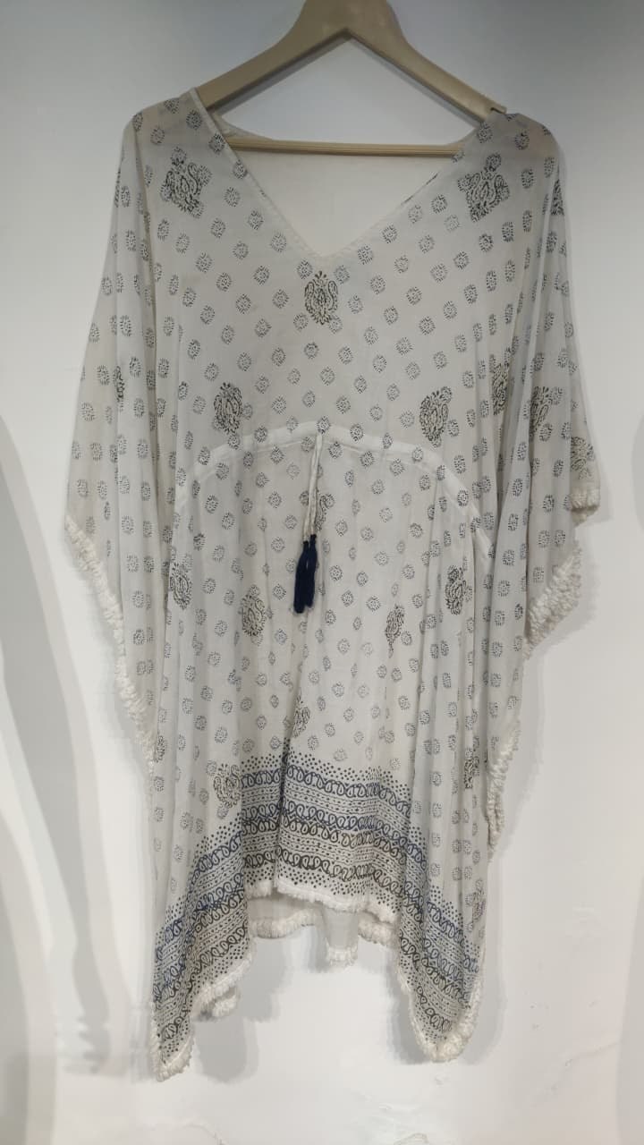 White printed cotton kaftan with pom pom hem on a hanger
