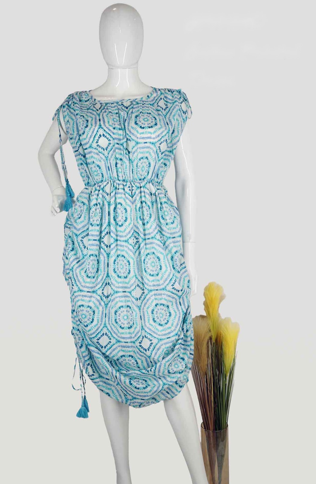Blue and white printed cotton dress with a drawstring waist and tassel ties on a mannequin