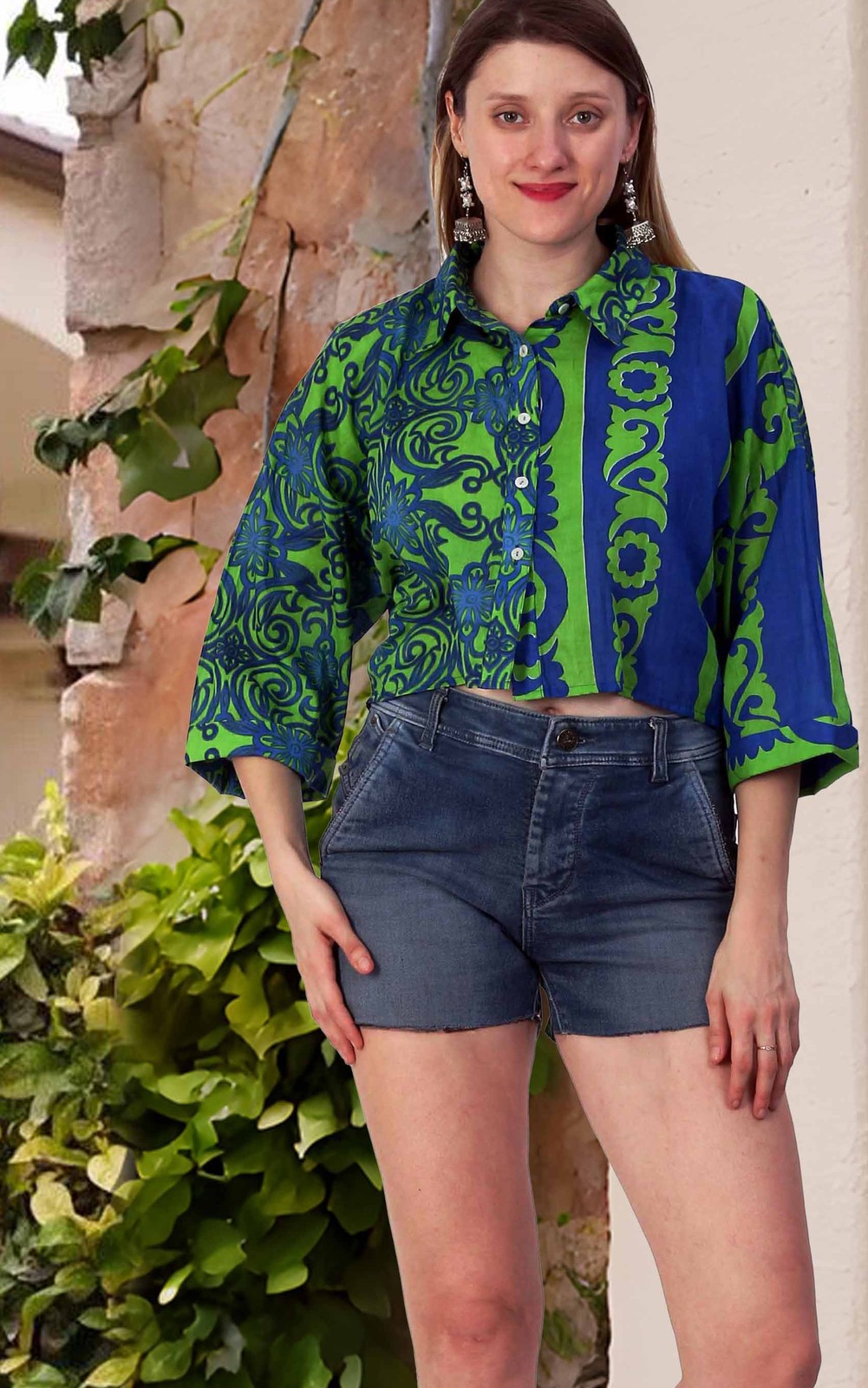 Woman in a green and blue printed cotton shirt top with denim shorts